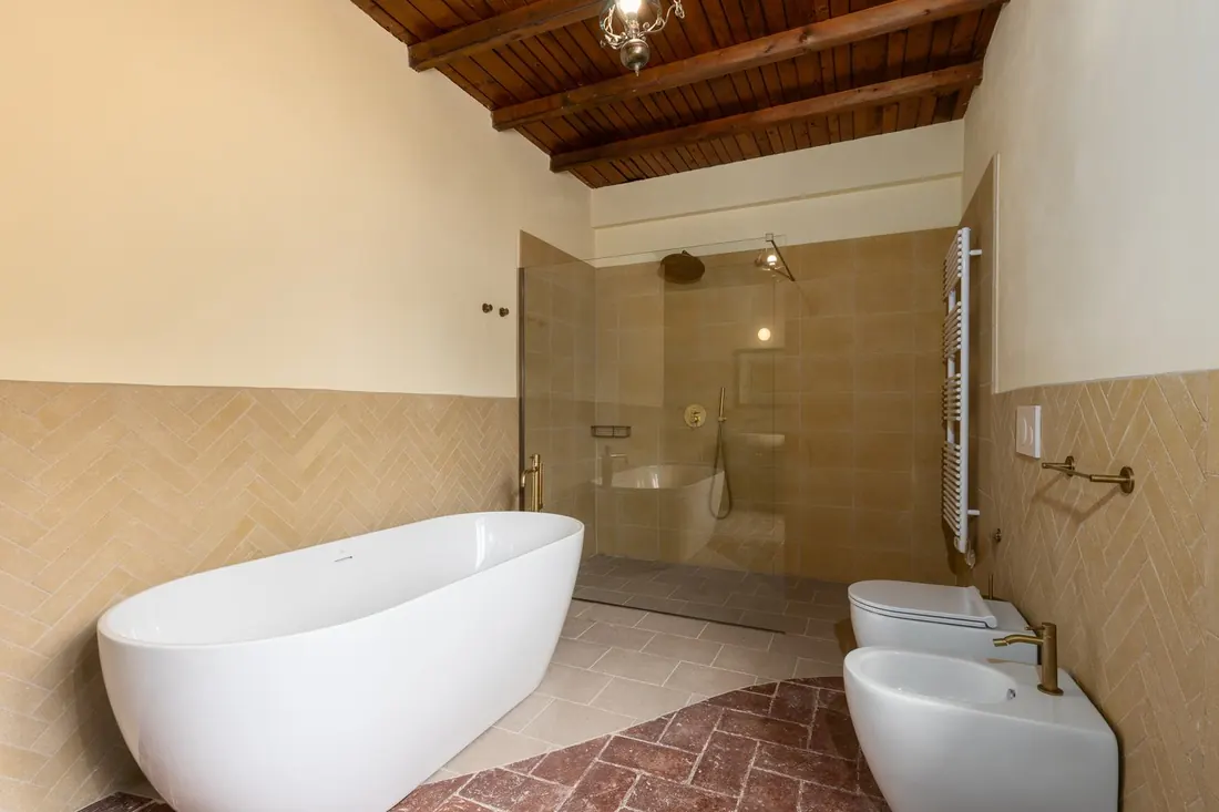 Bagno con vasca freestanding e soffitto in cotto
